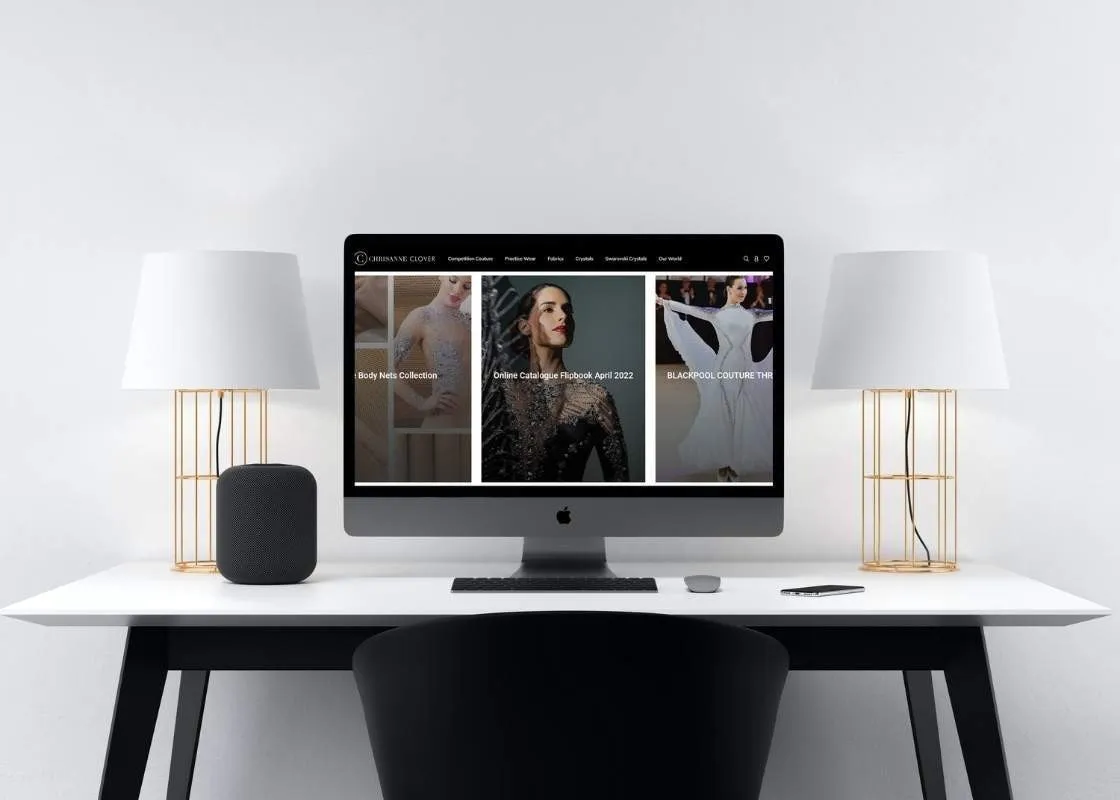 A mock-up of the Chrisanne Clover home page on a computer screen standing on a desk.